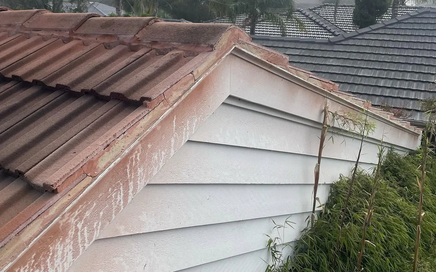 Cracked bedding and peeling paint on a gable end and ridge before restoration