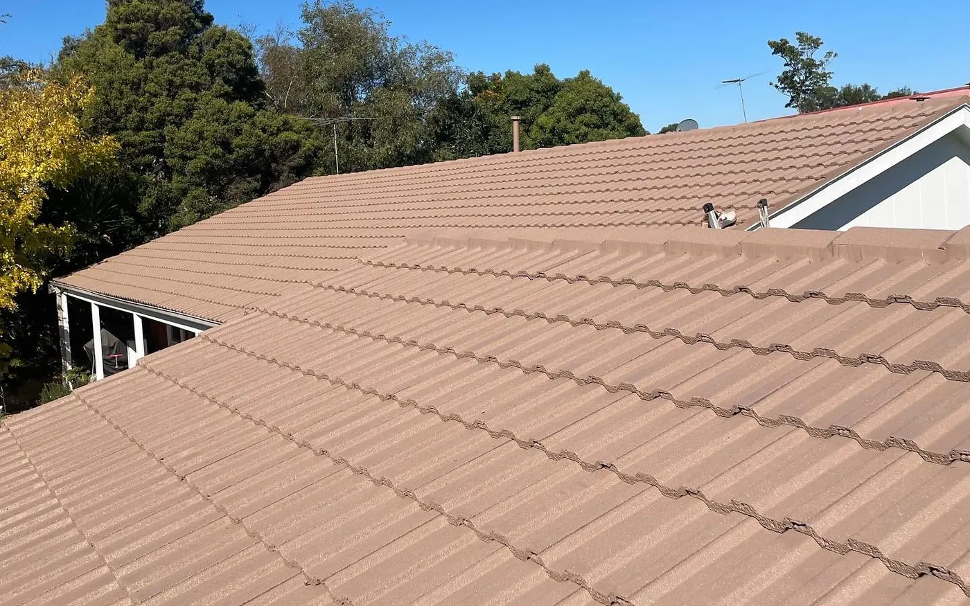 The same concrete tile roof after cleaning, re-bedding and a tan membrane coating