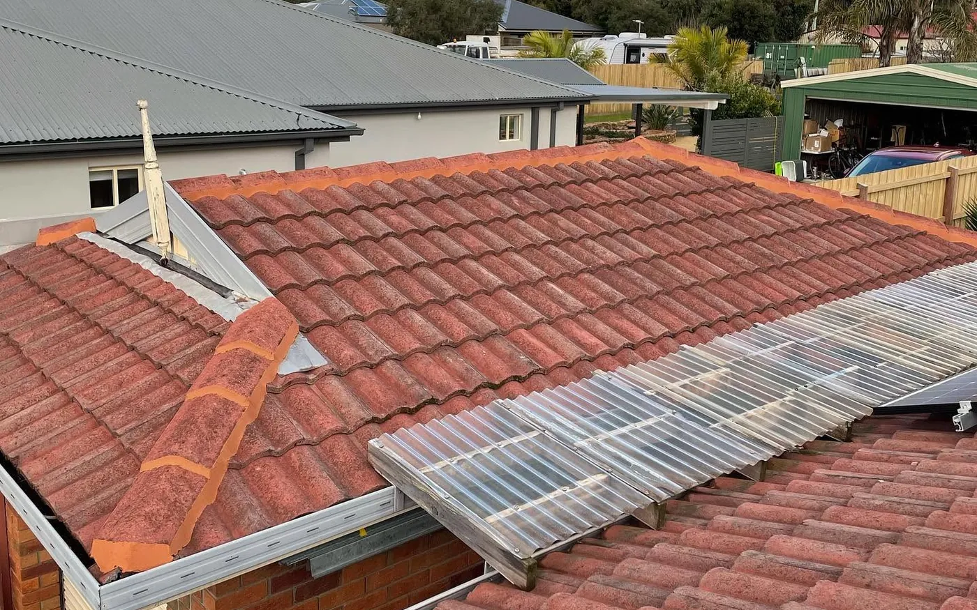 Faded and mossy terracotta-coloured concrete tile roof before restoration on the Sunshine Coast