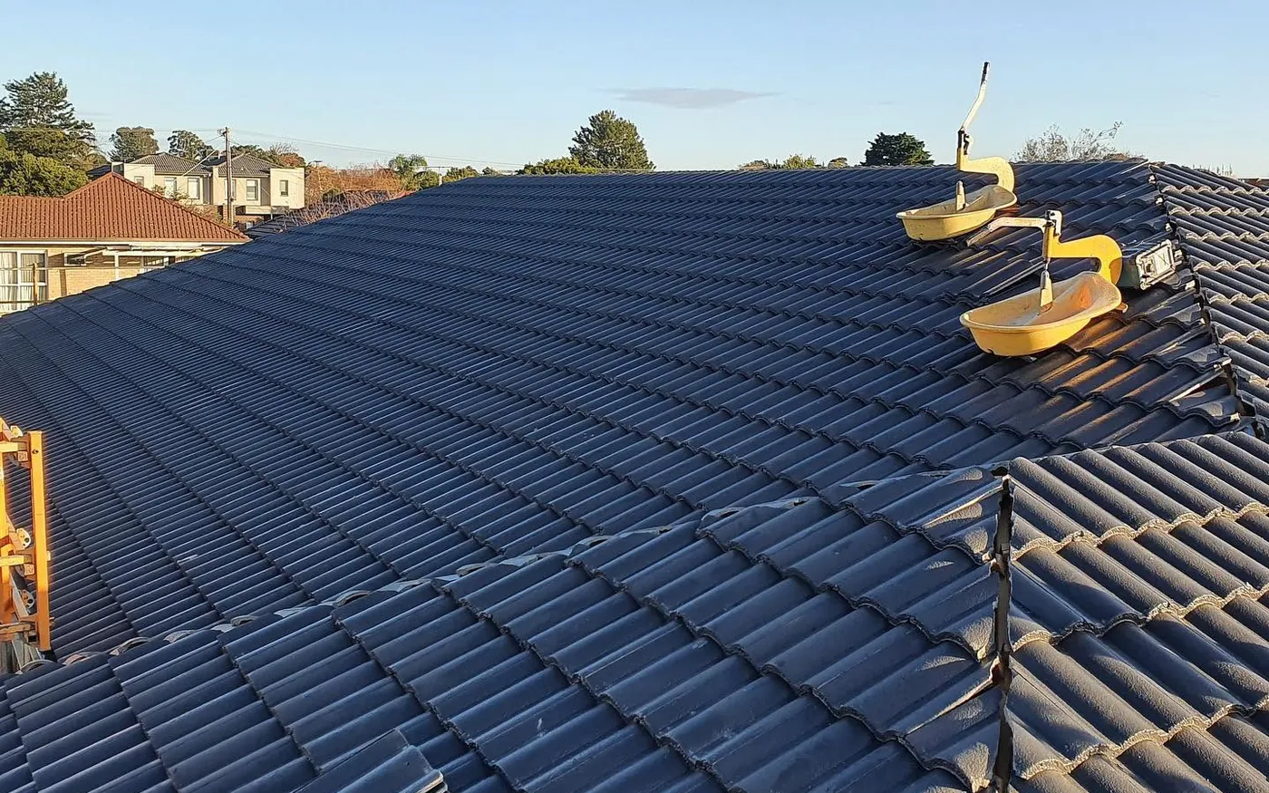Freshly coated charcoal tile roof with roof anchor points installed