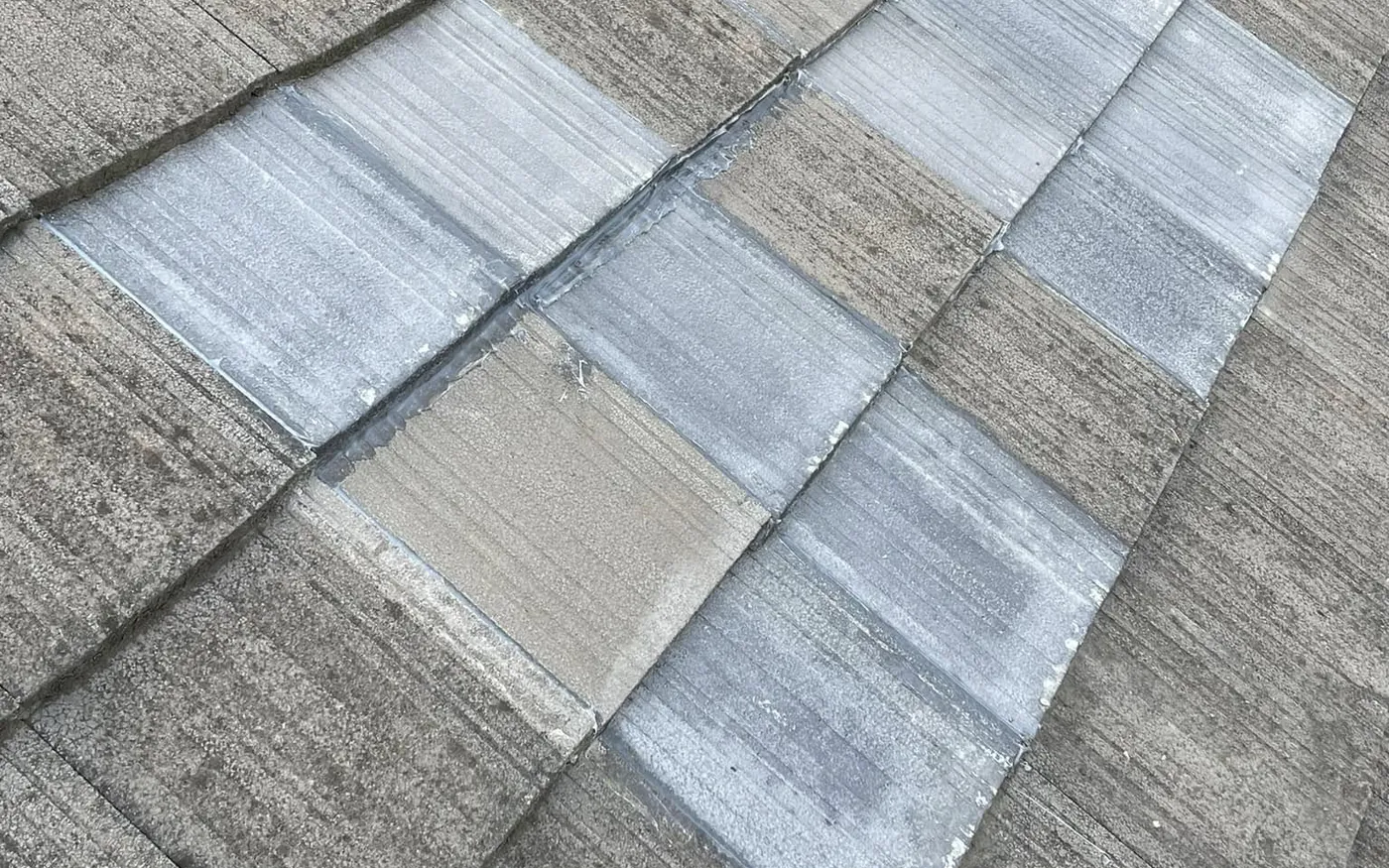 Broken concrete tiles replaced with matching tiles before the roof is coated